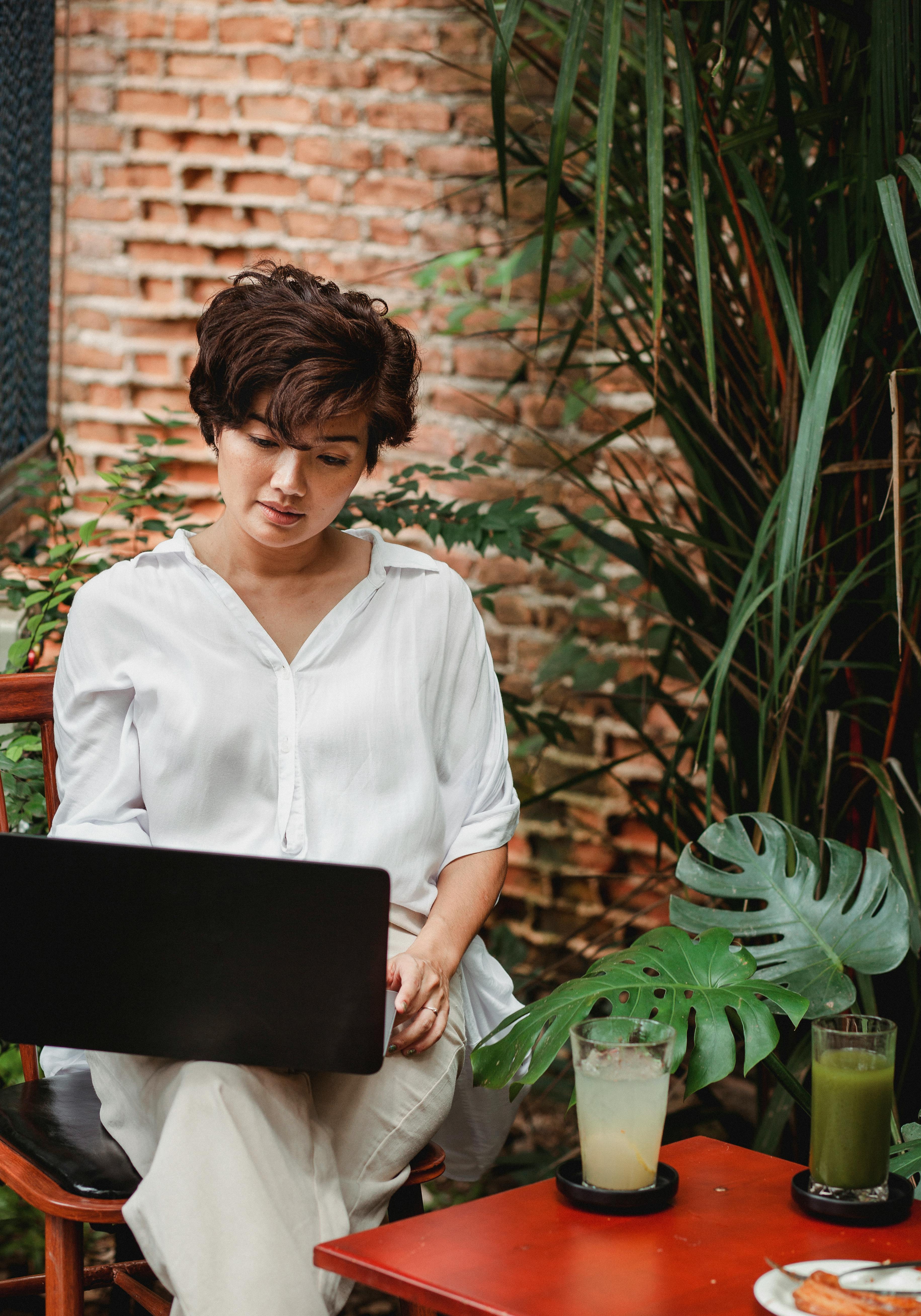 Middle-aged woman working as a freelancer on her laptop in a cafe.